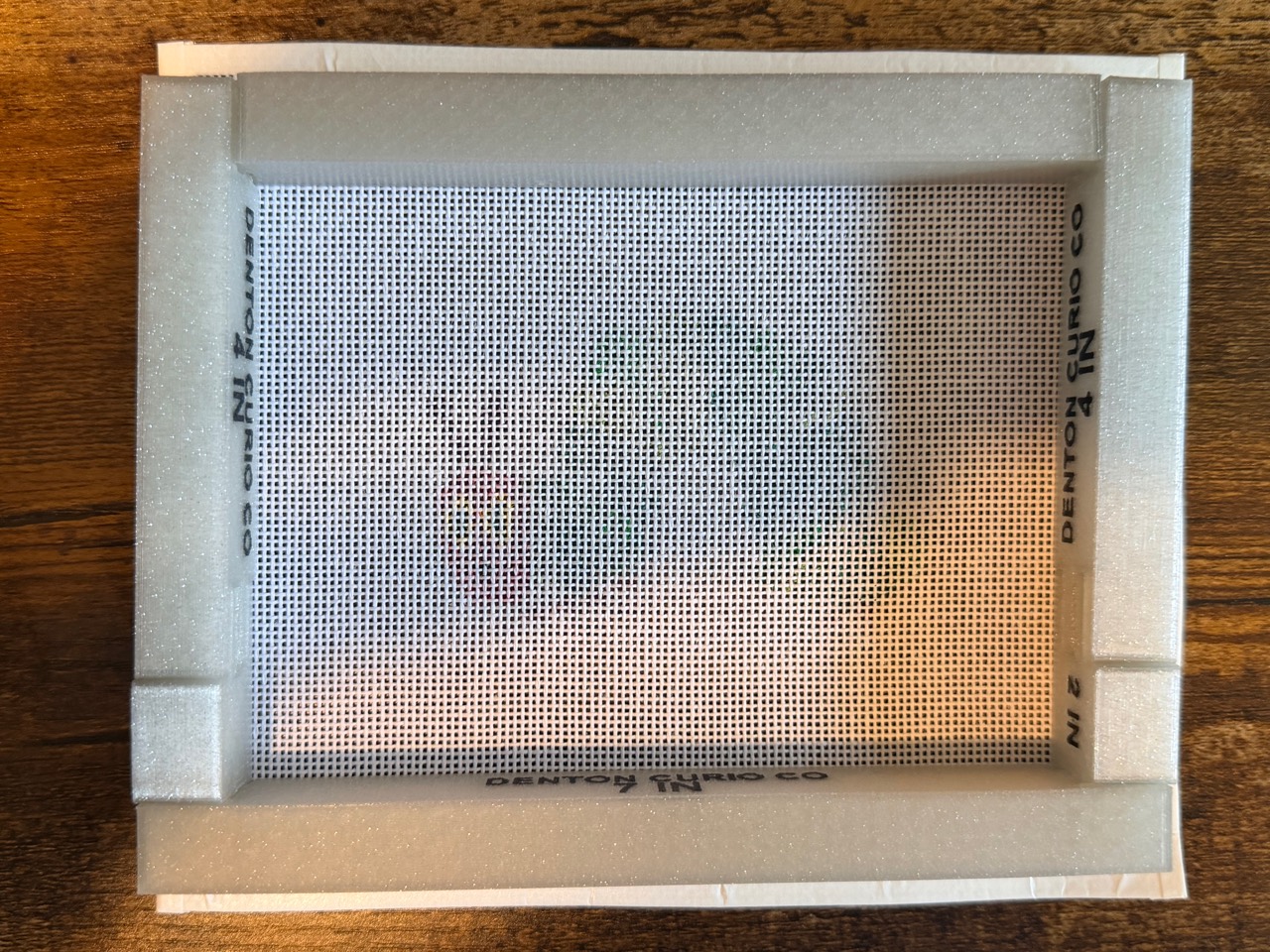 Back of a real white 4-inch Denton Curio Co frame, showing all four joined corners and the raised edge around a needlepoint canvas